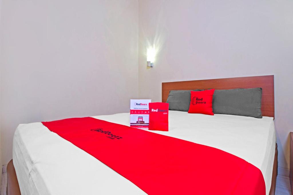 万隆万隆超级商城2号红门旅馆的一张红色和白色的床,上面有两个盒子