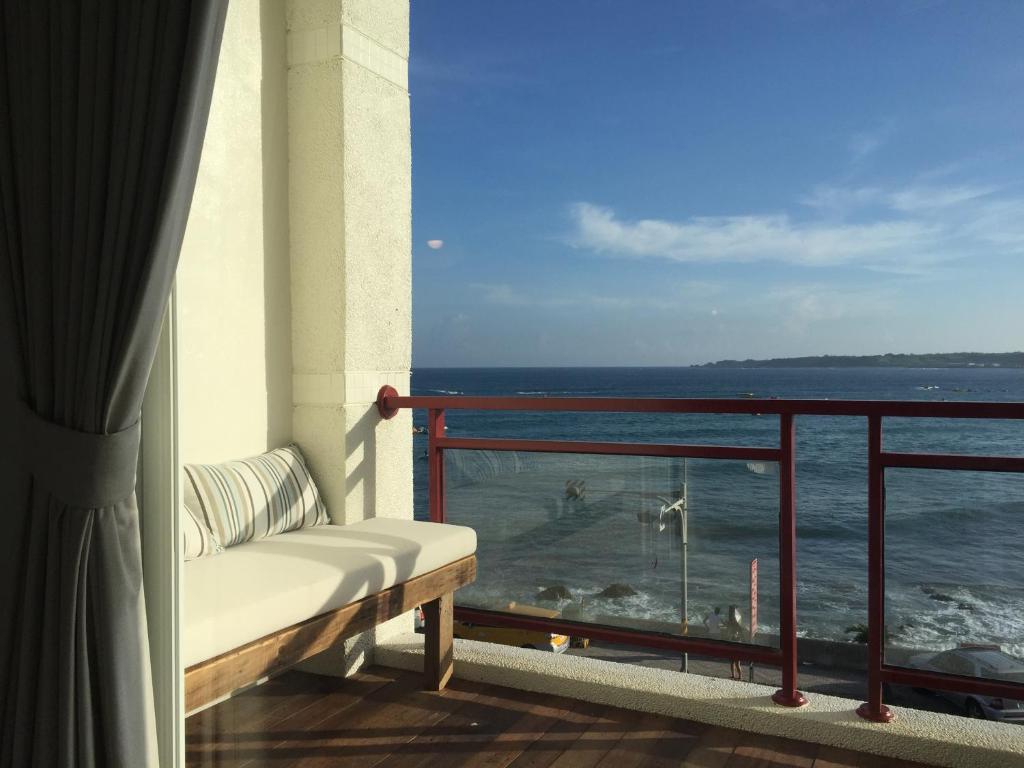 南湾迷路小章魚小旅館的阳台设有长凳,俯瞰着大海