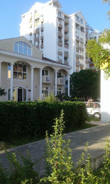 蒂瓦特Dena apartman Tivat的前面有灌木丛的白色大建筑