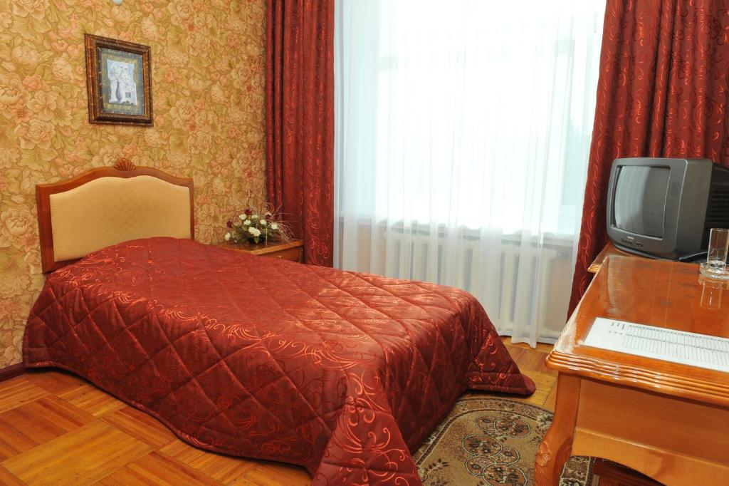 卡拉甘达Gostinichny Komplex Germes的一间卧室配有一张床和一台电视