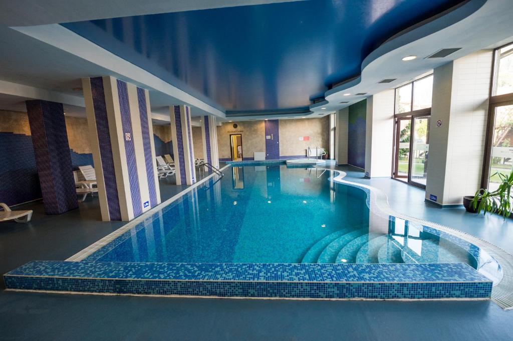切佩拉雷Rhodopi Home Hotel Chepelare - Half board的蓝色天花板建筑中的一个大型游泳池
