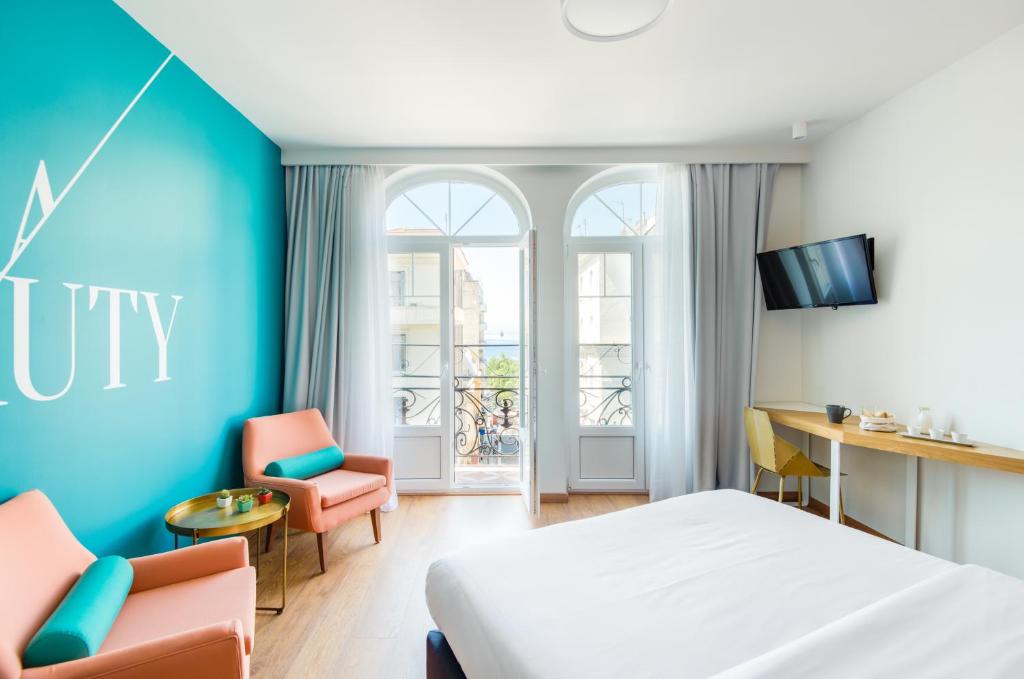 塞萨洛尼基Colors Urban Hotel Thessaloniki的酒店客房,配有一张床、一张桌子和椅子