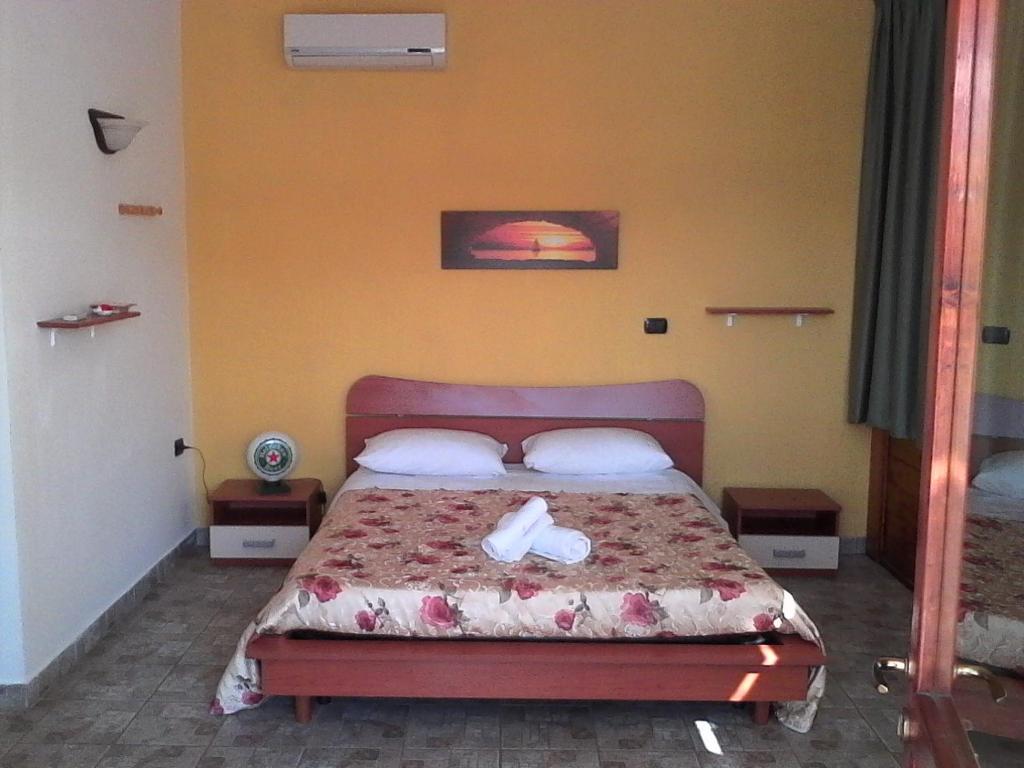 切萨雷奥港Oasi的一间卧室,床上有两双白鞋