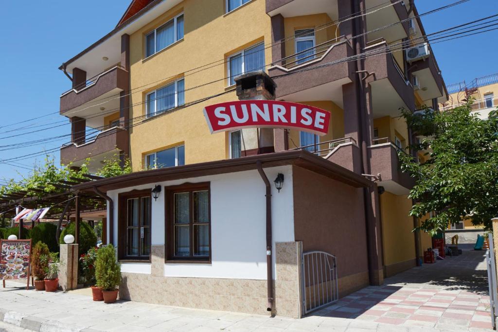 拉夫达Hotel Sunrise的上面有太阳升起标志的建筑