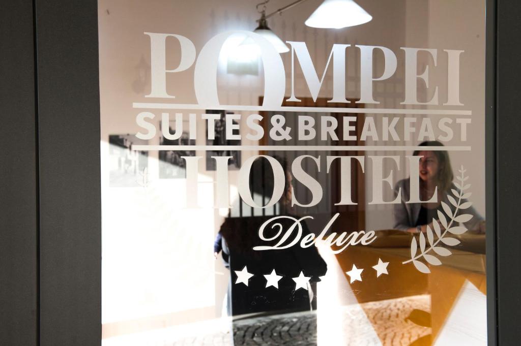 庞贝B&B Pompei Hostel Deluxe的窗户上标有阅读纯冲浪套装和早餐挂图的标志