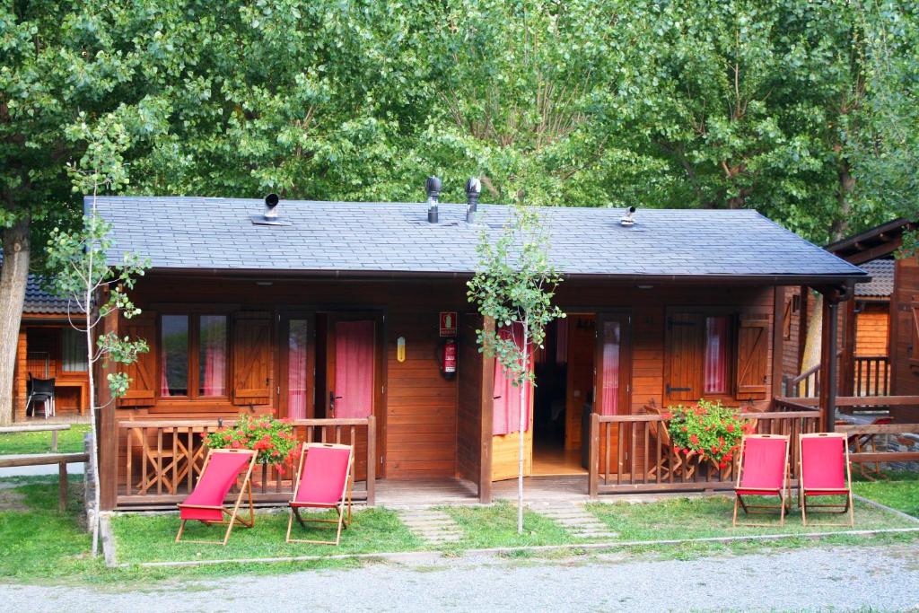 金格塔诺坎普露营简易别墅的小屋前方设有粉红色椅子