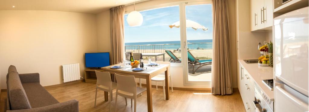 卡斯特尔德费尔斯Apartamentos Voramar的一间厨房和享有海滩美景的用餐室