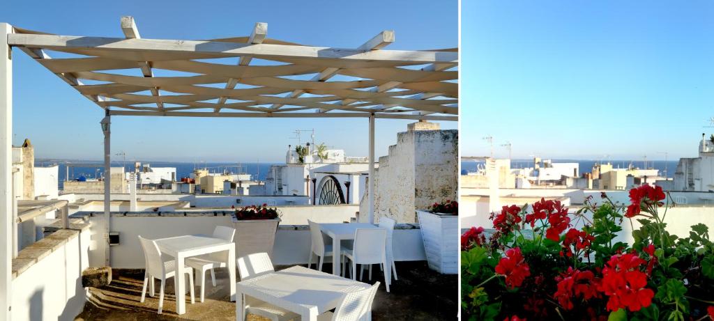 加利波利迪莫拉音乐餐厅住宿加早餐旅馆的屋顶上白色的桌子和椅子,花朵红色