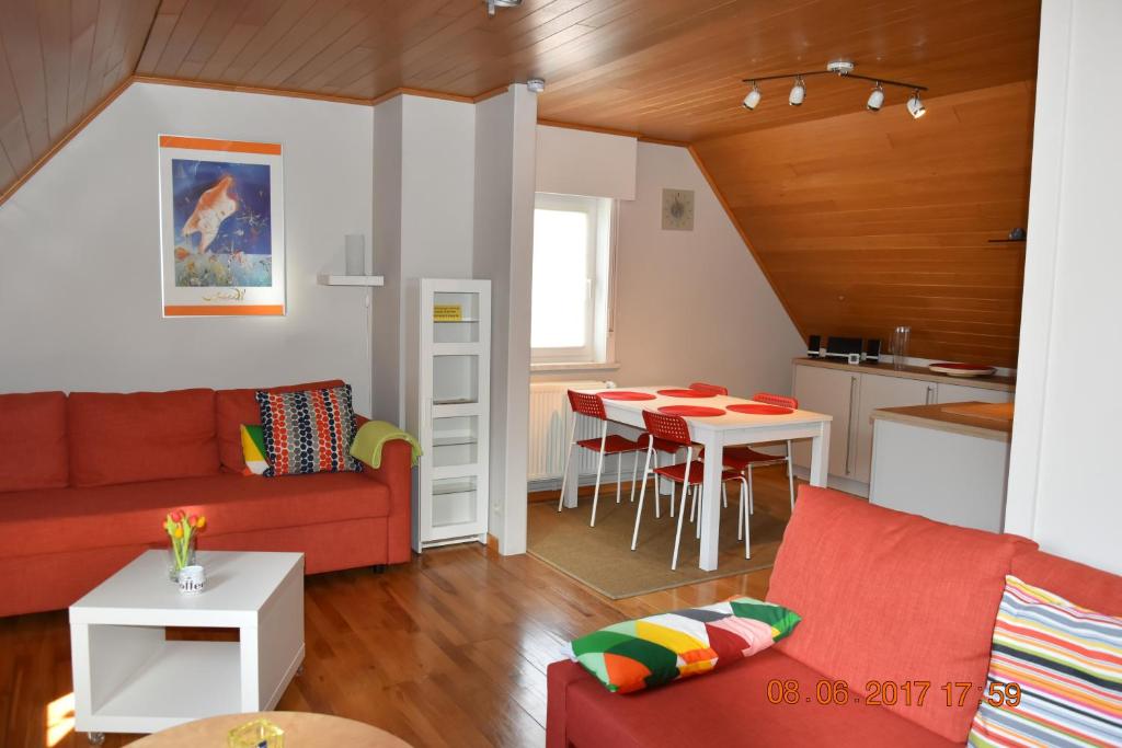 PoelkapelleDamon II的一间带红色沙发的客厅和一间厨房