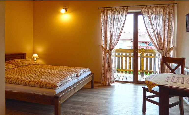 Spišské TomášovcePenzión Thamasy的一间卧室设有一张床和一个阳台的窗户。