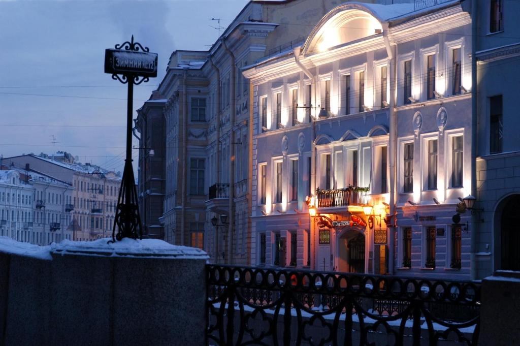 圣彼得堡普斯卡客栈酒店的一座有灯的建筑,前面有标志