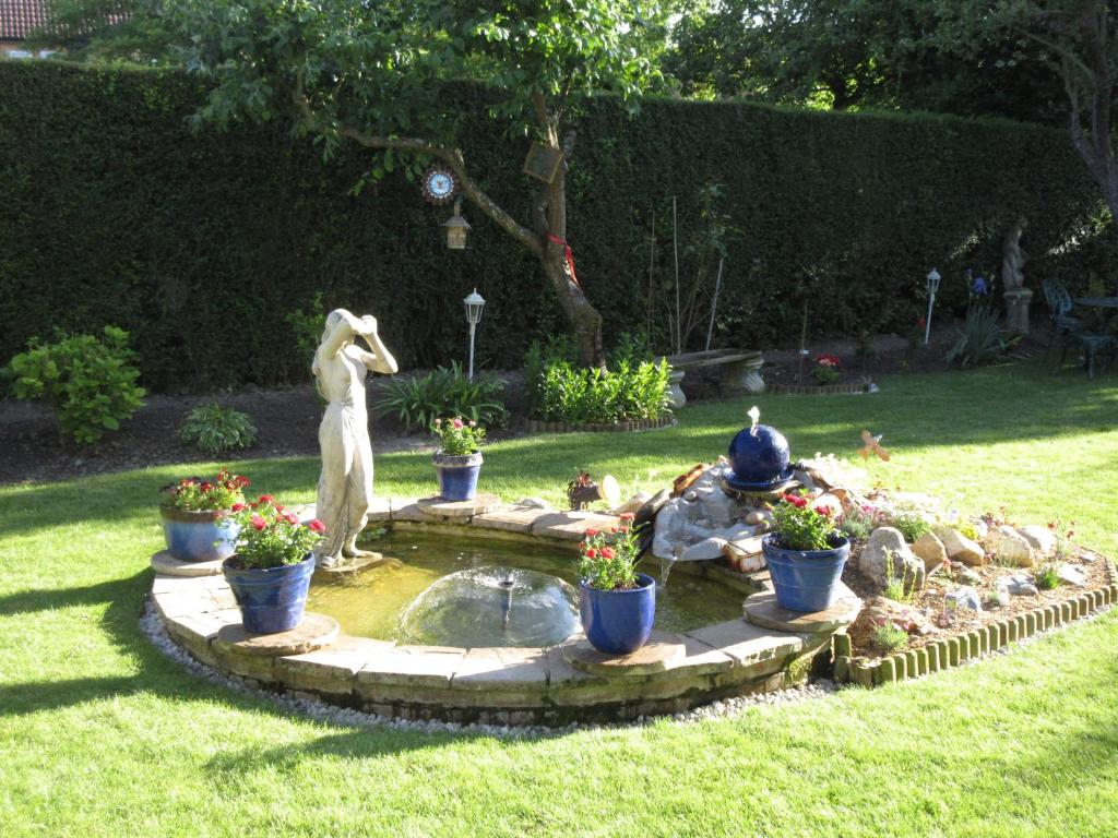 剑桥希尔附楼公寓的花园,花园内设有喷泉,在草地上设有雕像