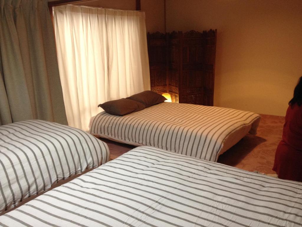 横滨山上分享旅馆的带窗户的客房内设有两张单人床。