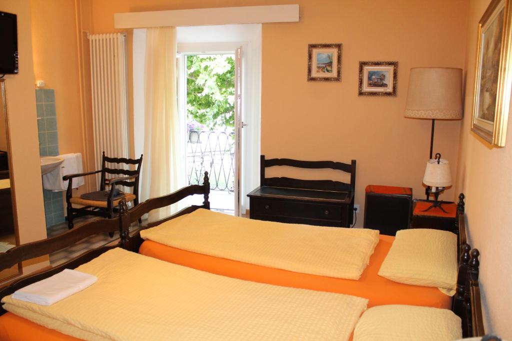 卡斯拉诺欧斯特里亚巴特罗旅馆的一间卧室设有两张床和窗户。