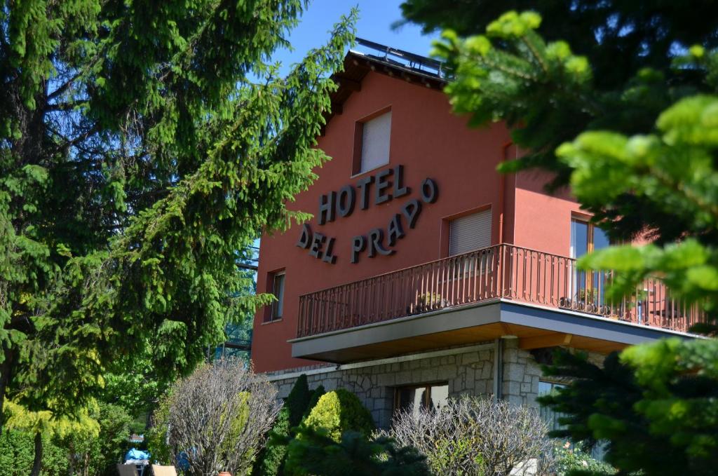 普奇塞达普拉多酒店的一座红色的建筑,设有阳台,上面写着