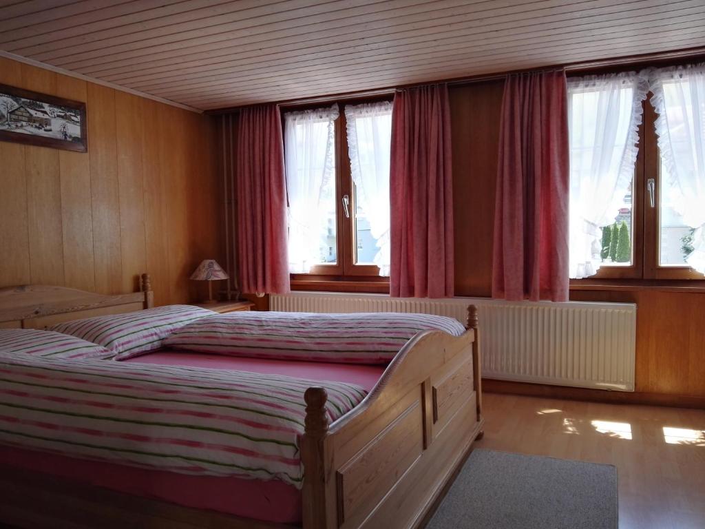 瓦尔岑豪森甘布里努斯匹萨宾馆的一间卧室配有一张带红色窗帘的大床