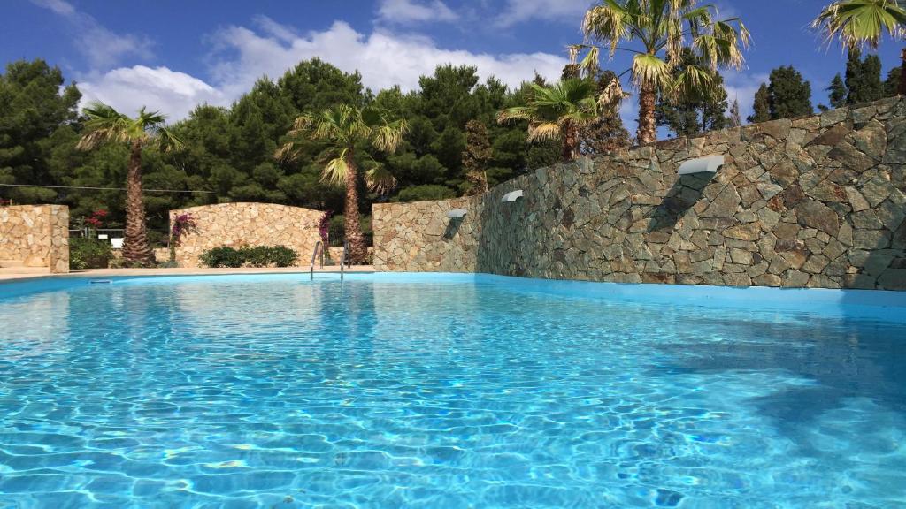 皮诺港Residence Elegance的蓝色海水和石墙的游泳池