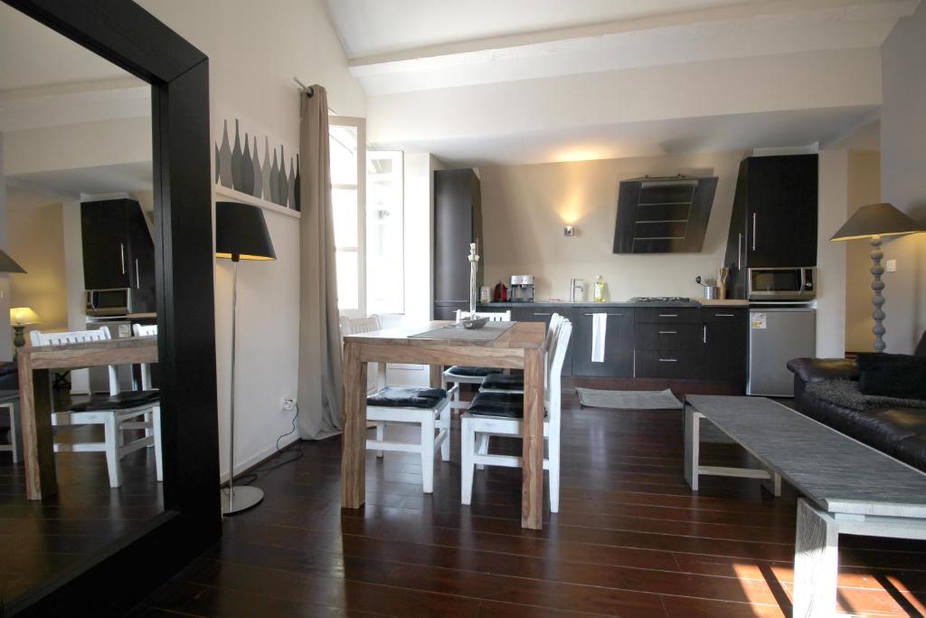 波尔多Appart Hypercentre - Le Saint Projet的厨房以及带桌椅的起居室。