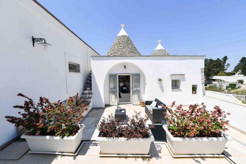 马丁纳弗兰卡Casa Gemma的前面有三株盆栽植物的白色建筑