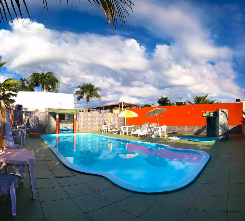奥林匹亚Pousada Sol Nascente的一个带椅子和遮阳伞的大型蓝色游泳池