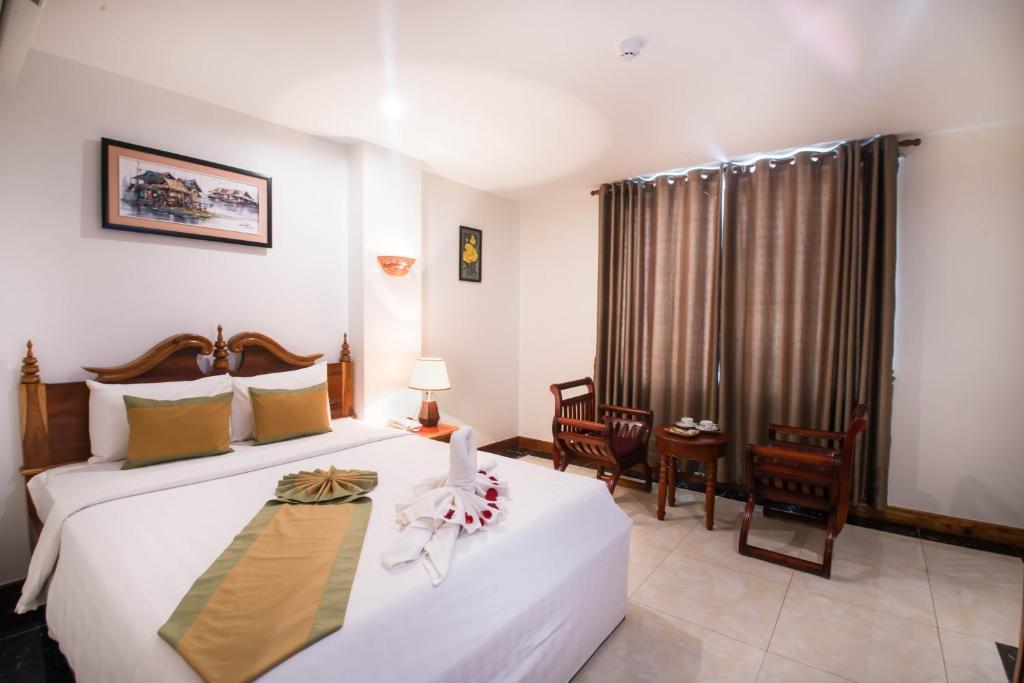 金边瑞莱克斯酒店的酒店客房设有两张床和窗户。