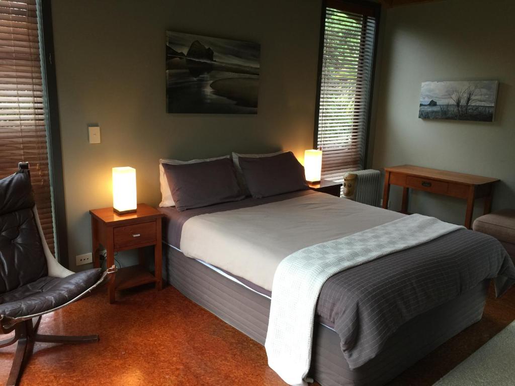 皮哈皮哈海滩旅馆的一间卧室配有一张床、一把椅子和两盏灯。
