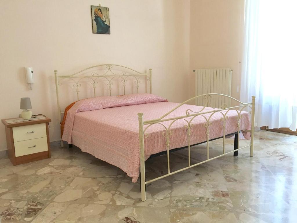 马蒂诺Casa nel Salento da Grace的一间卧室配有一张带粉色毯子的床