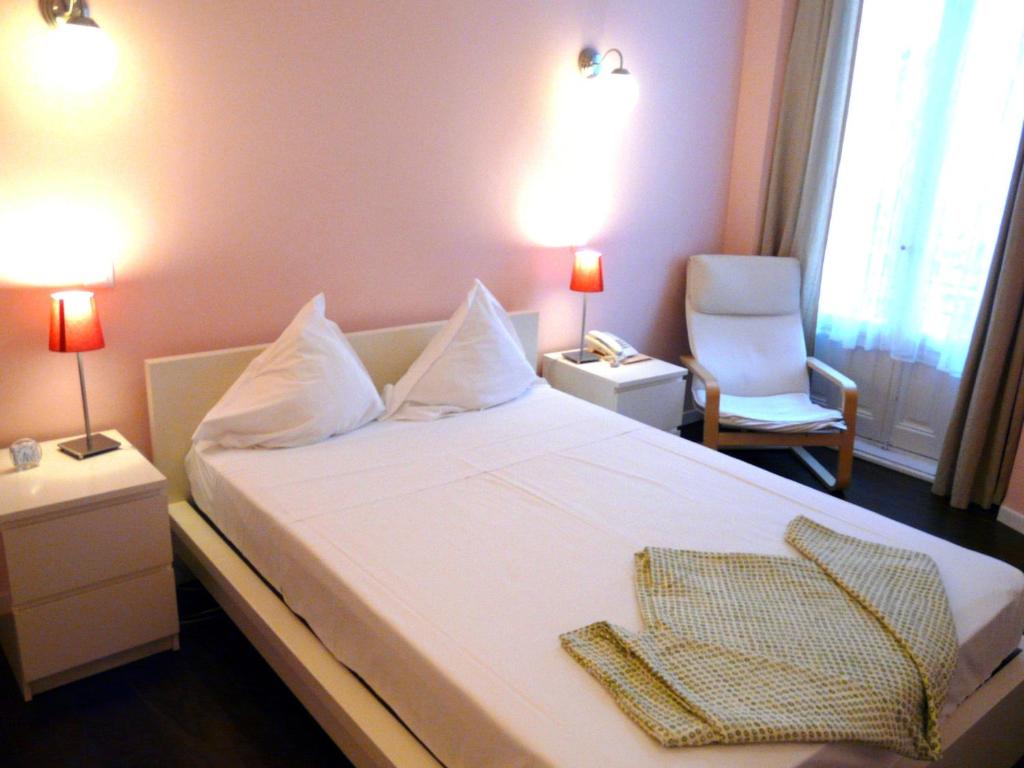 马德里Hostal Goyal Pizarro的一间卧室配有一张带椅子的床和两盏灯。