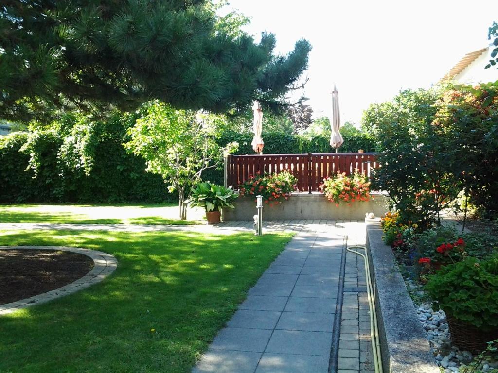 滨湖波德斯多夫Die Pension Reeh的花园设有围栏和鲜花小径