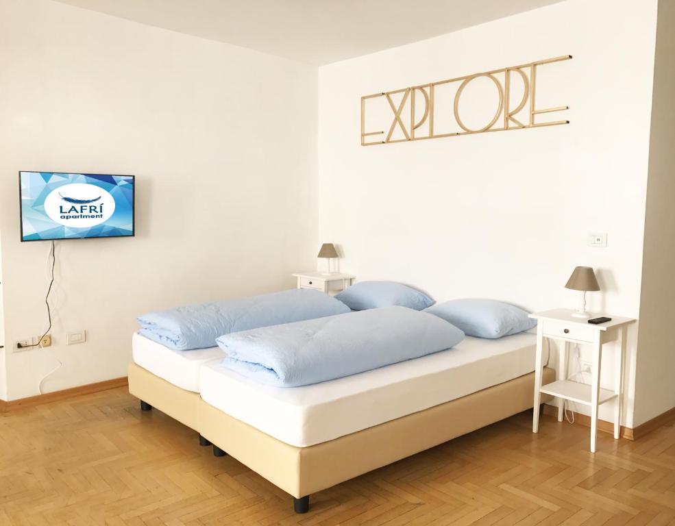 博尔扎诺Lafri Apartment的一间卧室配有一张带蓝色枕头的床。