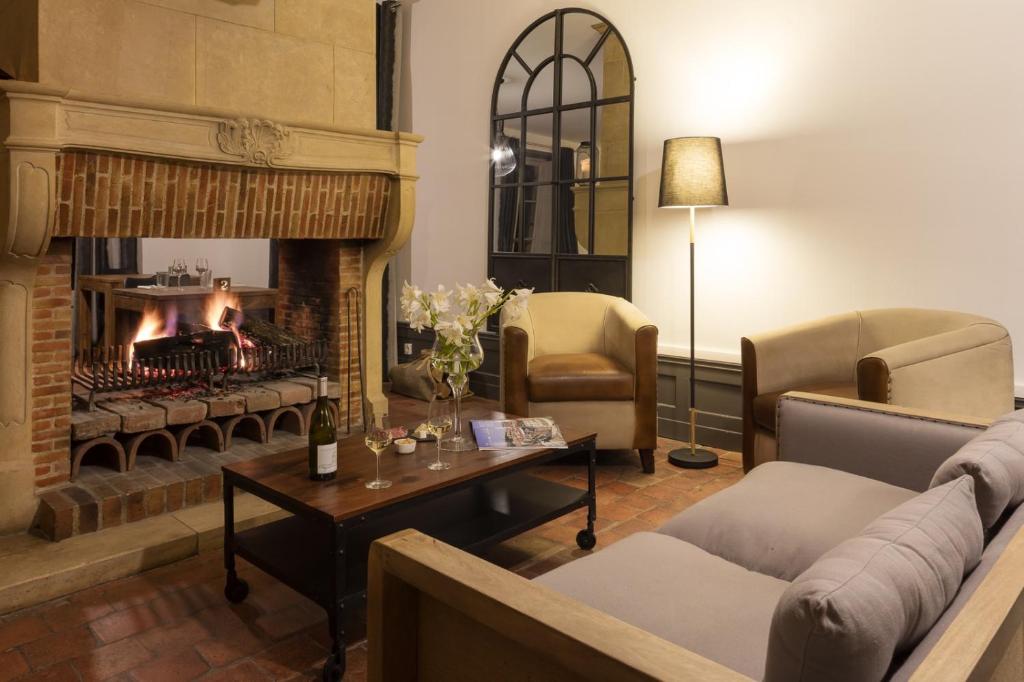 波拉斯Contact Hôtels Le Savigny & Spa的客厅设有壁炉、沙发和椅子