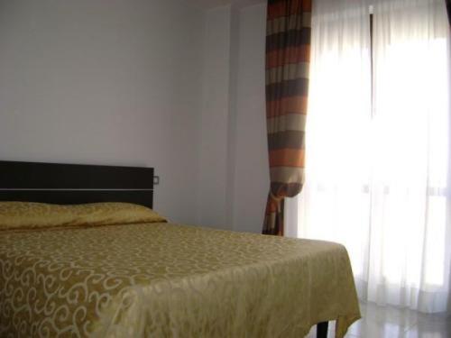 卡利亚里万特佳住宿酒店的一间卧室设有一张床和一个窗口