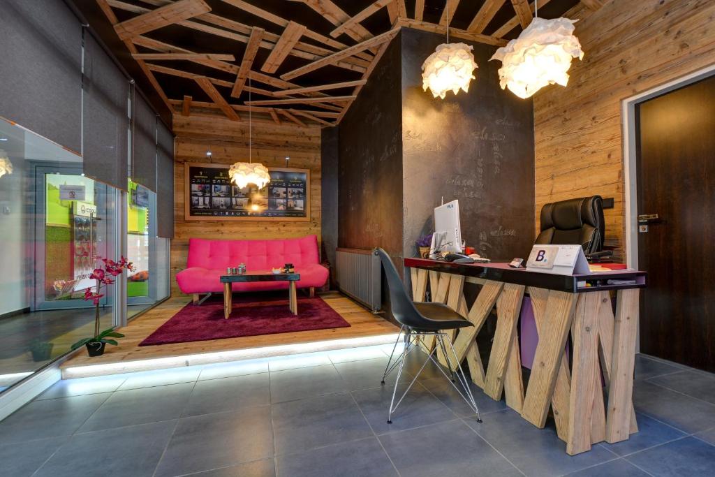 顺佩尔克爱丽莎公寓的一个带粉红色沙发和书桌的办公室