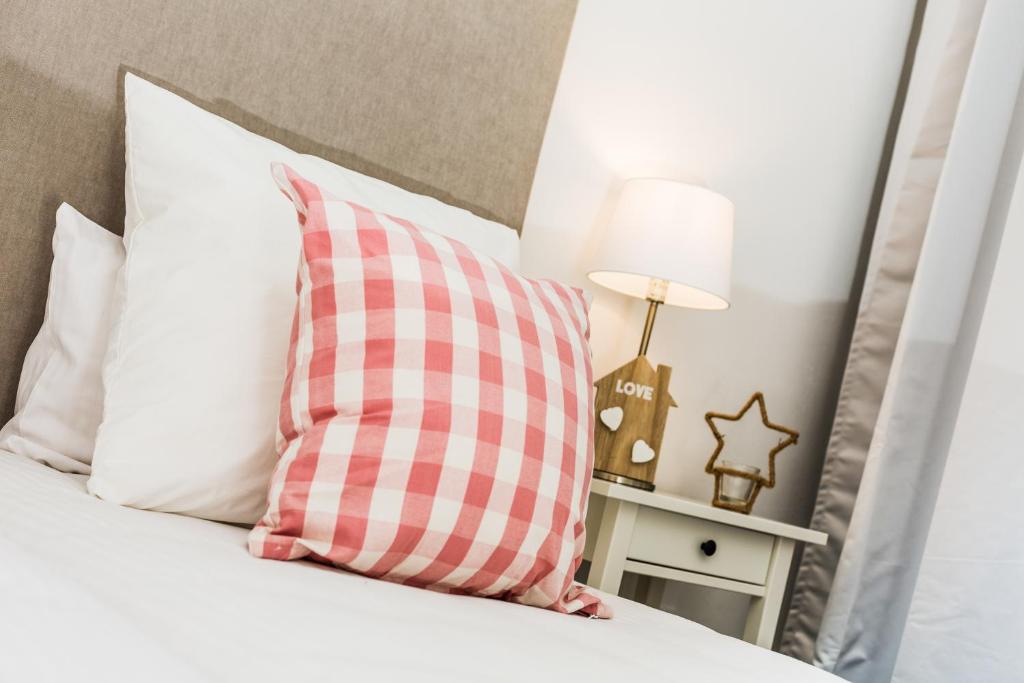科尔内拉德罗布雷加特Apartamentos Cornellalux 2的床上的粉红色和白色枕头