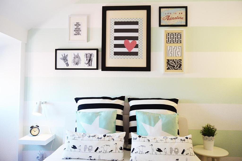 里斯本Belém Apartment的一间卧室配有一张带枕头的床,墙上挂有图片