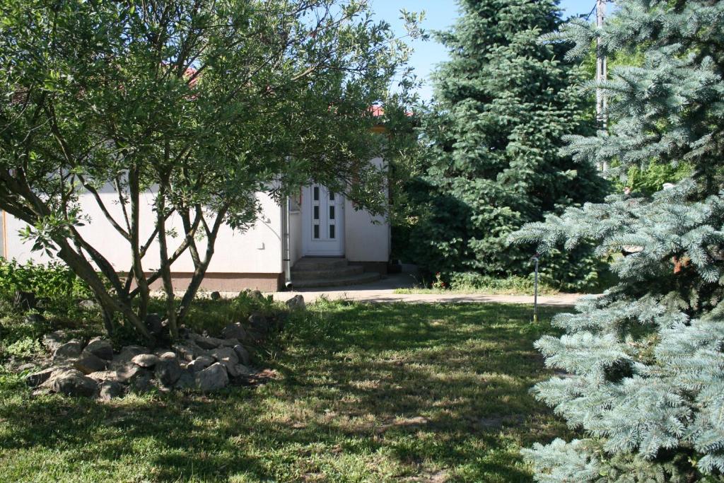 尼赖吉哈佐Levendula Apartman Nyíregyháza的一座带白色门和树木的花园