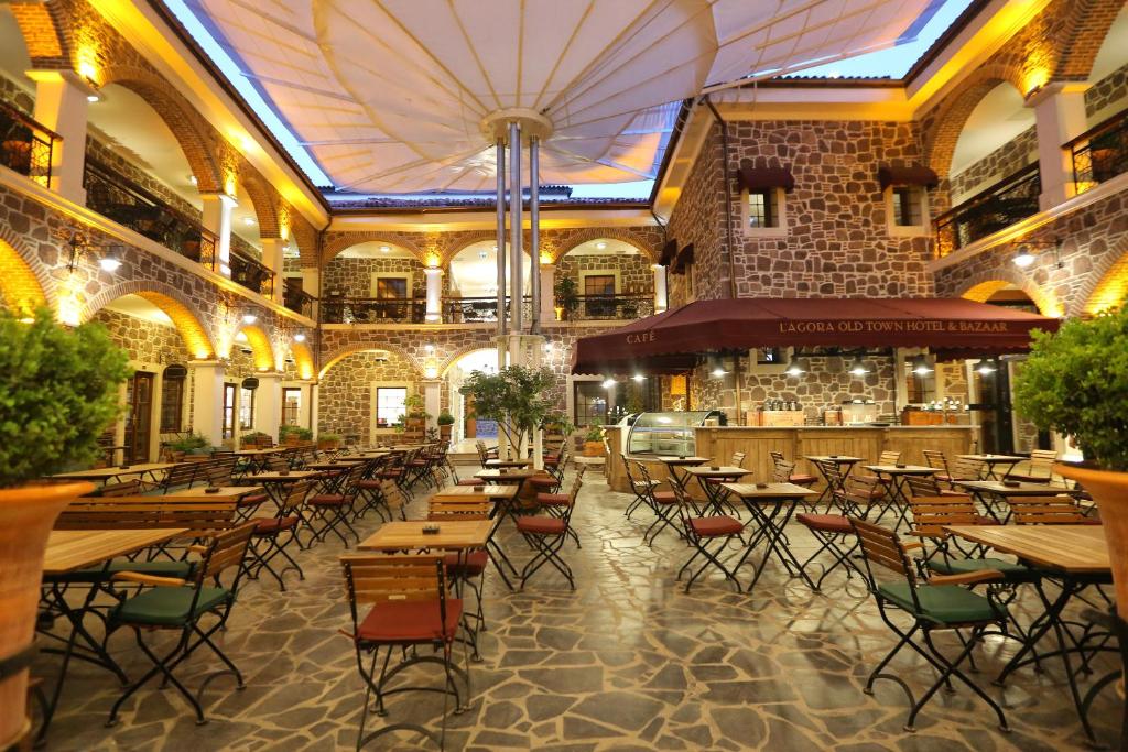 伊兹密尔L'Agora Old Town Hotel & Bazaar的一间带桌椅的餐厅和一间酒吧