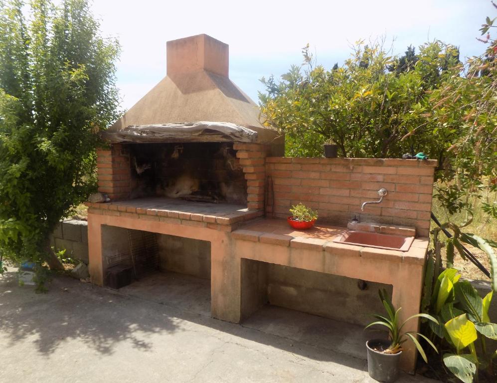 吉拉索莱Appartamenti Alessio的花园内带水槽的户外烤箱