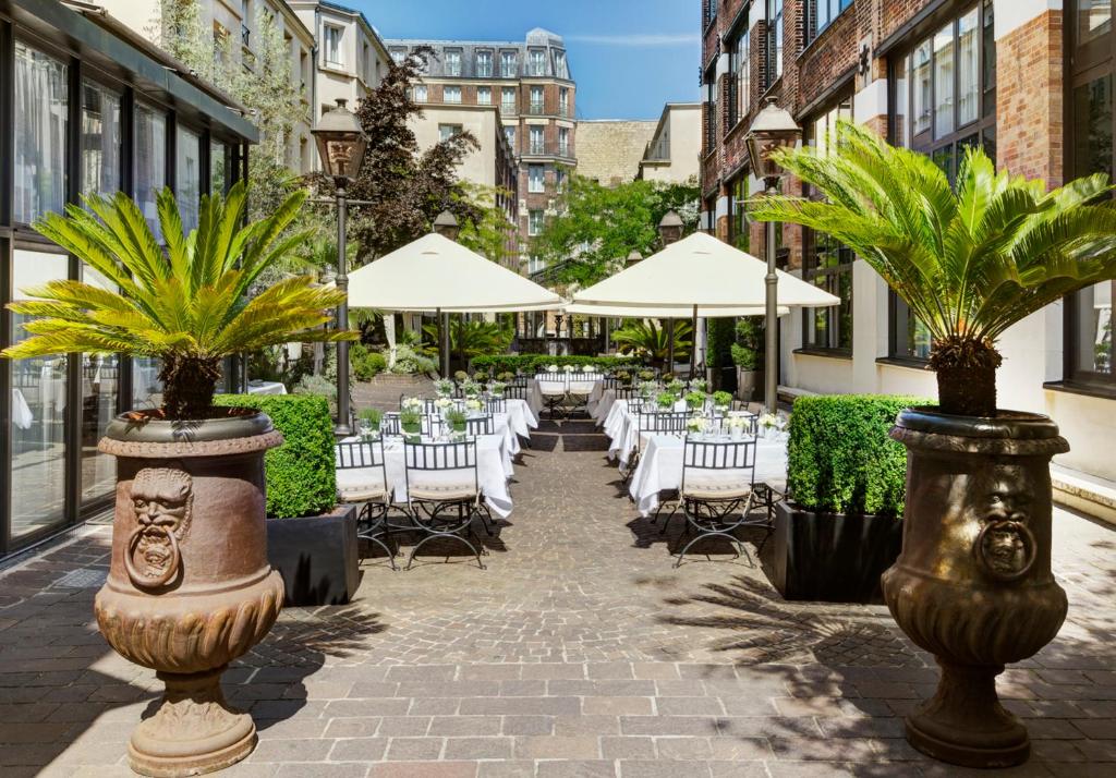 巴黎马莱公园酒店的一个带桌椅和遮阳伞的庭院
