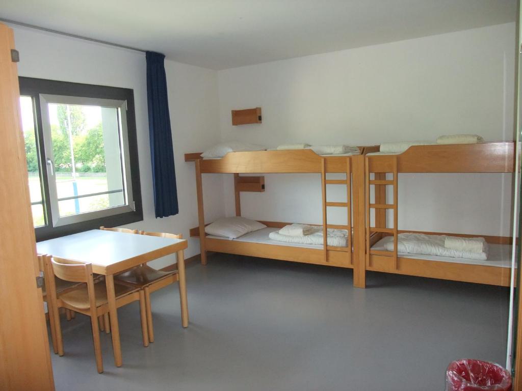 海德堡海德堡国际青年旅馆的客房设有两张双层床、一张桌子和一张桌子以及椅子。