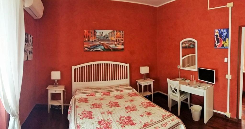 罗马CiaoRoma!的一间卧室设有红色的墙壁、一张床和一张书桌
