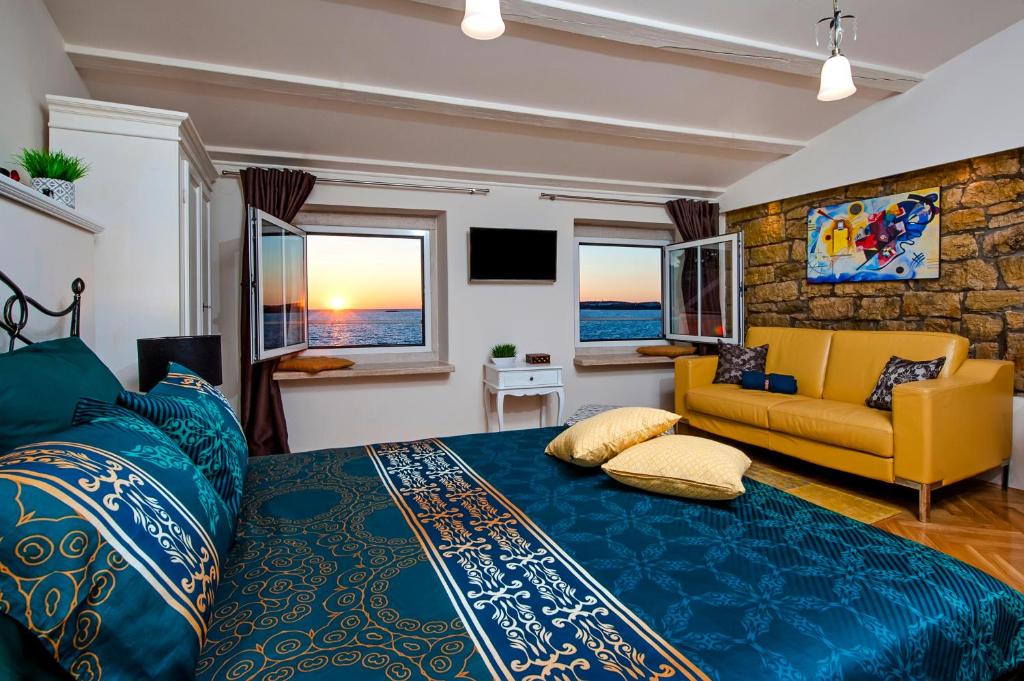 罗维尼Luxury Studio '936'的一间卧室配有蓝色的床和黄色的沙发