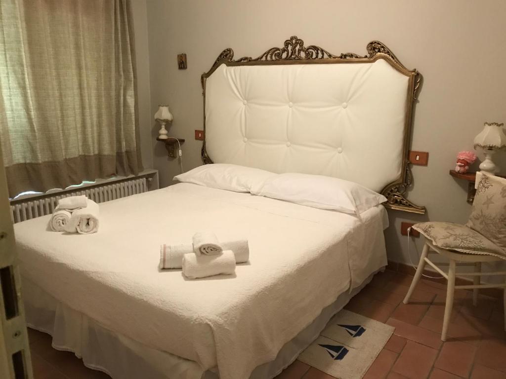 马里纳迪马萨Ancora bilocale的卧室配有白色床和毛巾