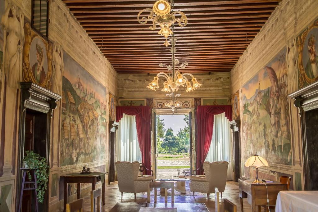 埃斯泰Azienda Agricola Marin的墙上挂有绘画作品的房间和吊灯