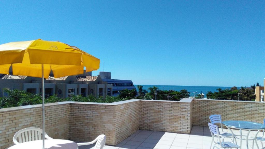 弗洛里亚诺波利斯Brava Apart Hotel的天井配有黄色雨伞和桌椅