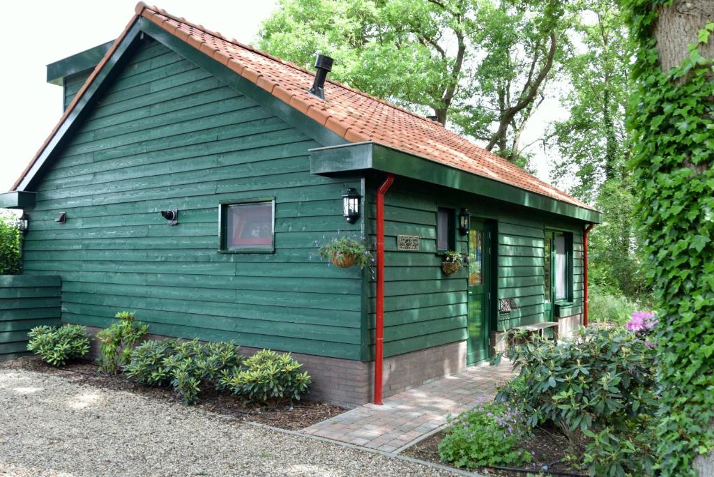 GorsselGastenverblijf Kleinkamperfoelie的一座带红色屋顶的绿色房子