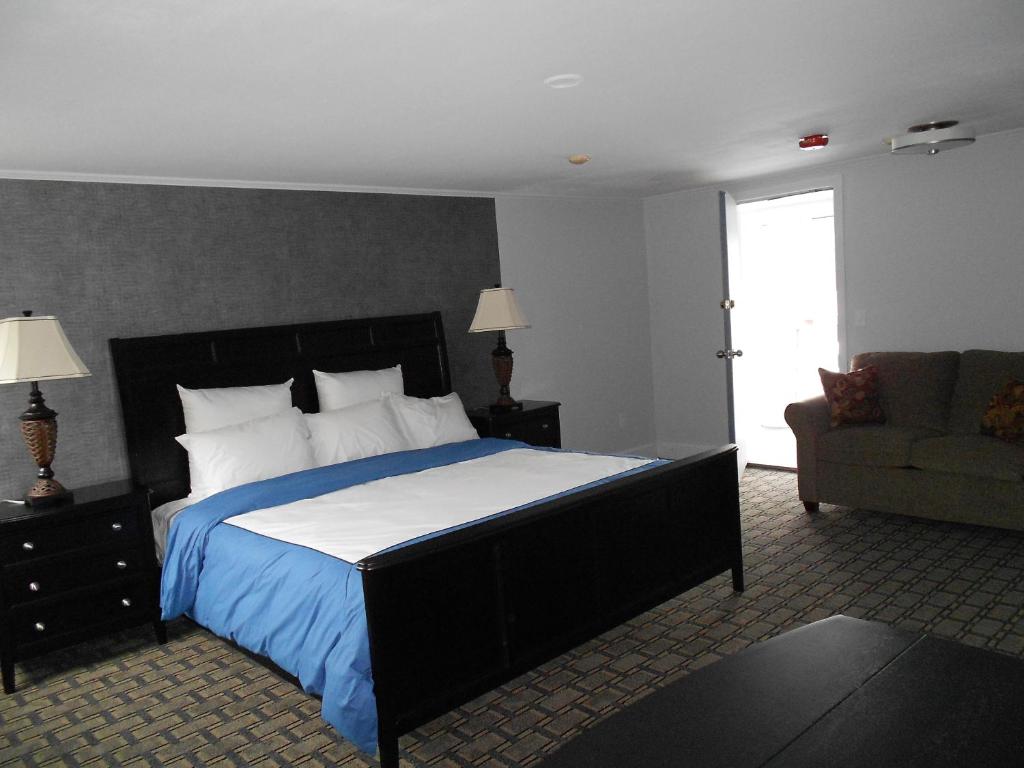 南雅茅斯红磨房汽车旅馆的一间卧室配有一张大床和一张沙发