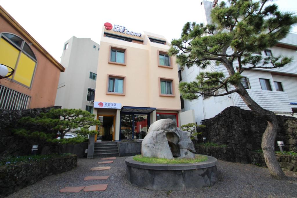 济州市大同酒店的一座有树的建筑前的雕像