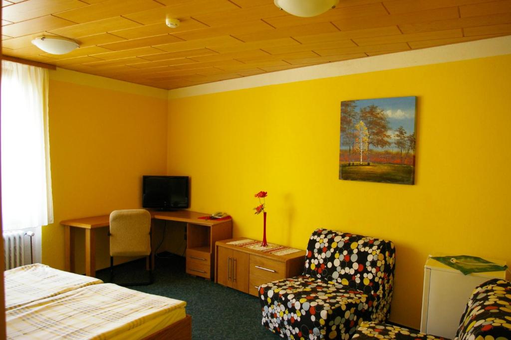 拉贝河畔乌斯季彭逊杜尔旅馆的一间卧室配有一张床、一张桌子和一把椅子