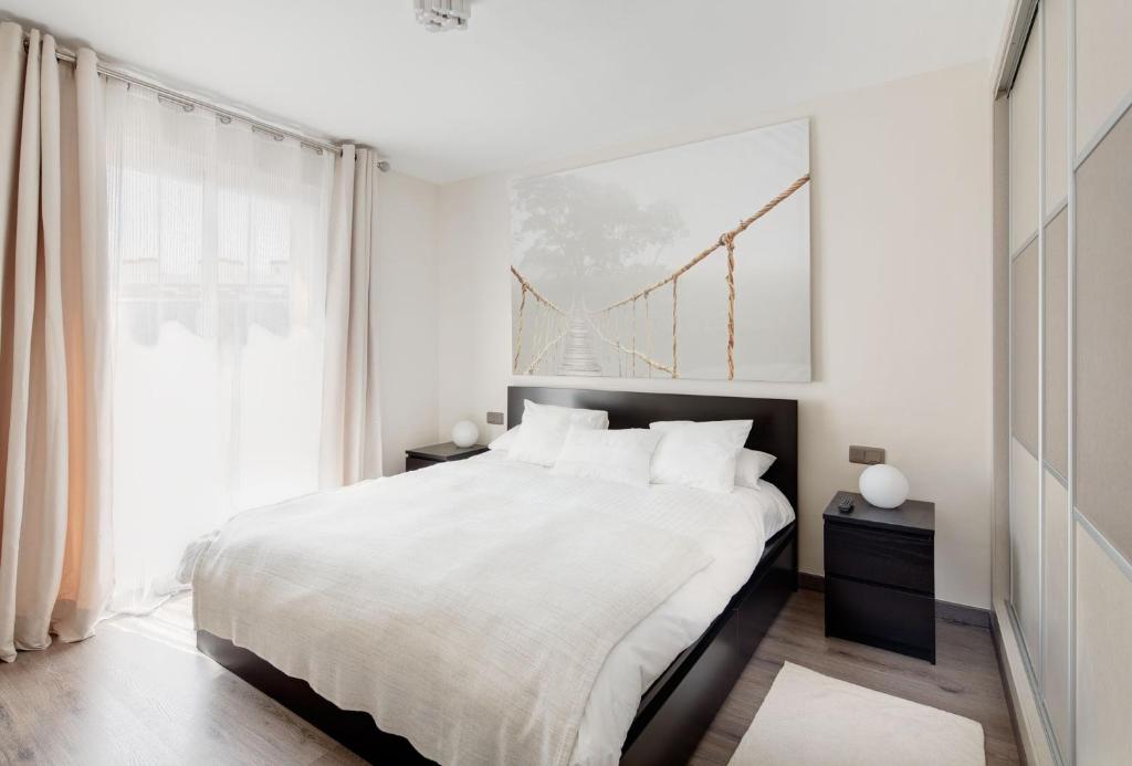 马贝拉马贝拉豪华公寓 的白色的卧室设有一张大床和一个窗户